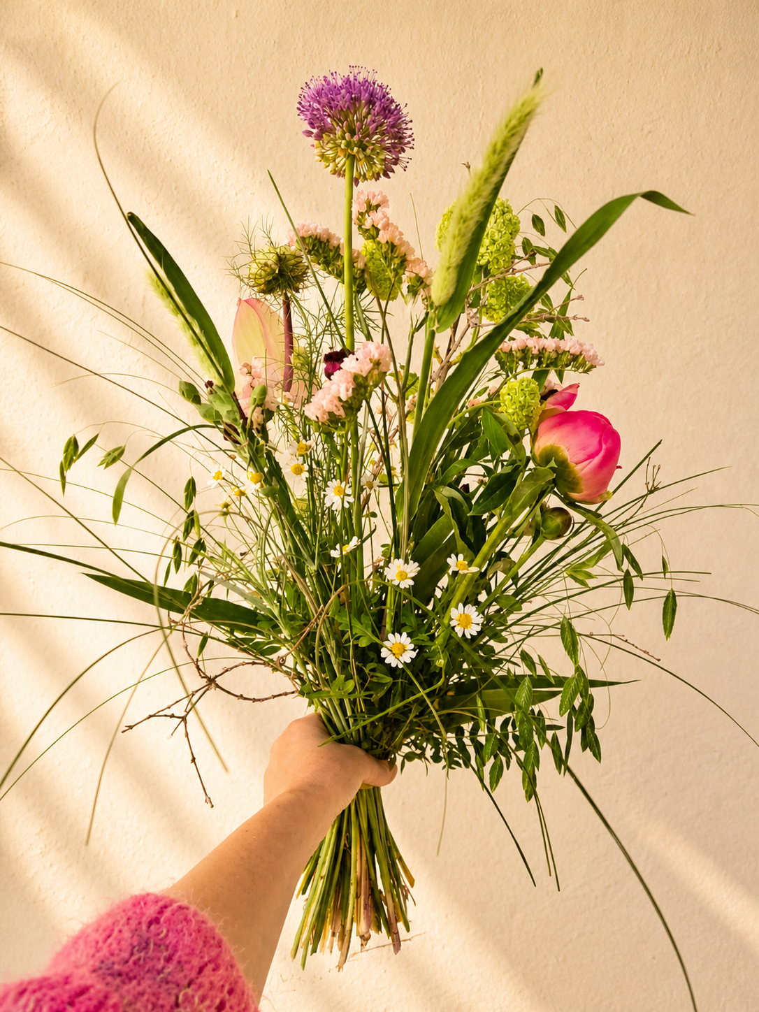 Høj og luftig buket med sæsonens vilde blomster og grønt i naturligt, organisk udtryk.