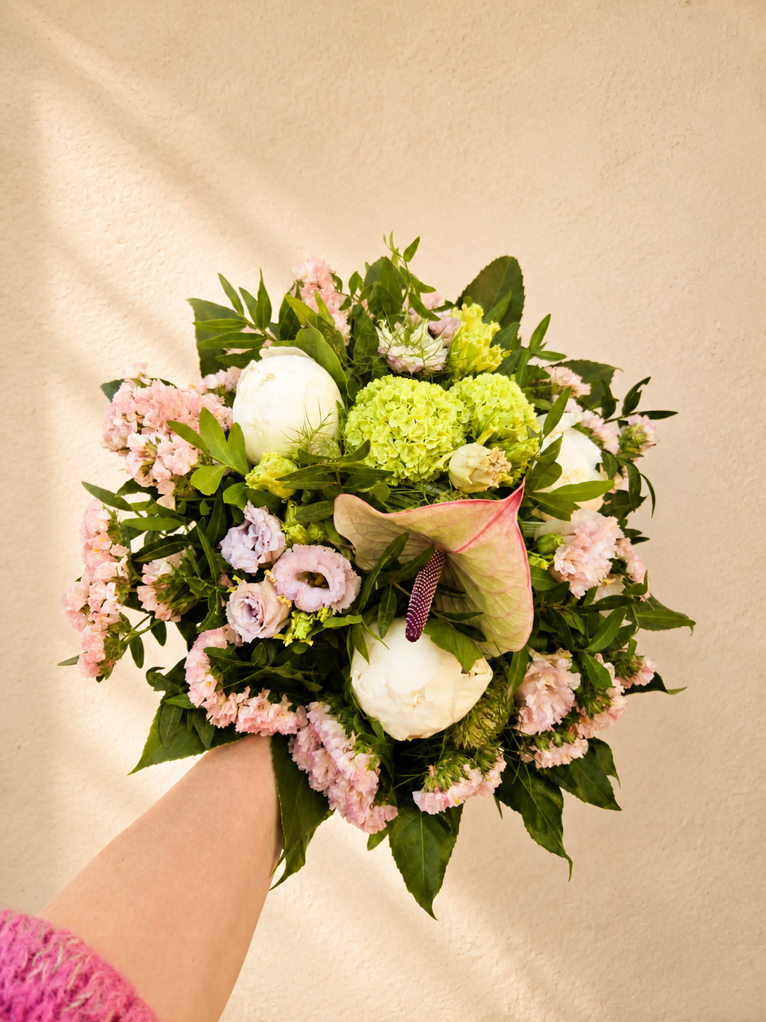 Forårsbuket med blomster i lyse og rosa nuancer med grønt – elegant og romantisk forårsbuket.